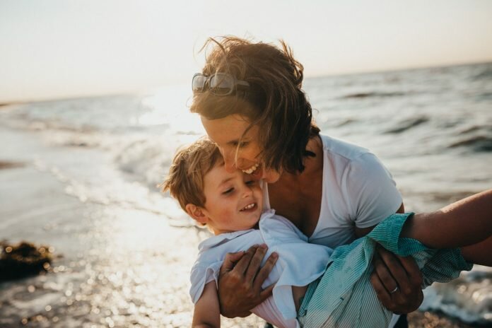 Mother with son at beach photo by Xavier Mouton Photographie Survivor Lit magazine amplifying voices of sexual assault survivors